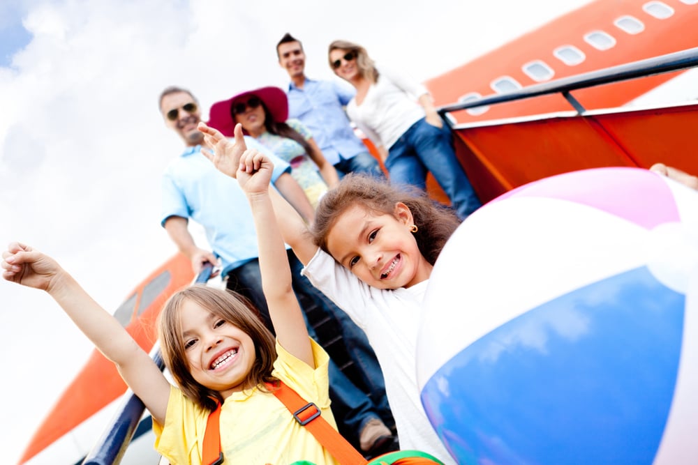 Happy kids traveling by airplane for their vacations